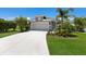 Well-kept single-Gathering home featuring a spacious driveway leading to a two-car garage and lush landscaping at 4815 Deep Creek Ter, Parrish, FL 34219