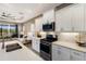 Bright kitchen featuring white cabinets, stainless steel appliances, a peninsula counter with sink, and access to the living room at 4815 Deep Creek Ter, Parrish, FL 34219