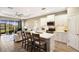 Open-concept kitchen featuring white cabinets, stainless steel appliances, and an island with seating overlooking the living area at 4815 Deep Creek Ter, Parrish, FL 34219