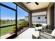 Relaxing screened lanai features comfortable seating with backyard views of landscaped yard and pond at 4815 Deep Creek Ter, Parrish, FL 34219