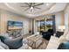 Inviting living room features a tray ceiling, ceiling fan, sliding glass doors, and comfortable seating at 4815 Deep Creek Ter, Parrish, FL 34219