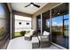 Relaxing screened-in patio featuring comfortable seating with views of the landscaped backyard and lake at 4815 Deep Creek Ter, Parrish, FL 34219