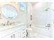 Bright bathroom features a modern sink, large mirror, and a bathtub with white tiled walls and updated fixtures at 4815 W Sunset Blvd, Tampa, FL 33629