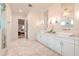 Elegant bathroom featuring double sinks, white cabinets, modern fixtures and a walk-in shower at 4815 W Sunset Blvd, Tampa, FL 33629