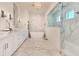 Bright bathroom featuring a freestanding tub, marble accents, dual sinks, and glass-enclosed shower at 4815 W Sunset Blvd, Tampa, FL 33629