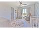 Cozy Bedroom showcases a lion rug, comfy chair, and a white crib near a bright window with sheer curtains at 4815 W Sunset Blvd, Tampa, FL 33629