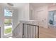 Bright hallway with hardwood floors, chandelier and stairway featuring black metal railings at 4815 W Sunset Blvd, Tampa, FL 33629