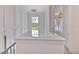 Bright hallway featuring a modern chandelier, classic paneled walls, and serene view from the landing window at 4815 W Sunset Blvd, Tampa, FL 33629