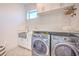 Well-equipped laundry room with front-load washer/dryer, granite countertop, herringbone tile backsplash, and storage at 4815 W Sunset Blvd, Tampa, FL 33629