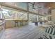 A spacious screened-in patio with an outdoor kitchen, game area, and elegant seating under a stunning wood-paneled ceiling at 4815 W Sunset Blvd, Tampa, FL 33629