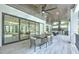 Stylish outdoor patio with a dining table, sliding glass doors, and an outdoor kitchen with modern appliances at 4815 W Sunset Blvd, Tampa, FL 33629