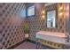 Stylish powder room featuring designer wallpaper, modern vanity, and gold fixtures at 4815 W Sunset Blvd, Tampa, FL 33629