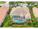 An aerial view of the home featuring a screened-in pool, a tile roof, and lush landscaping at 4912 Sabal Lake Cir, Sarasota, FL 34238
