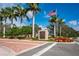 Inviting Turtle Rock community entrance with lush landscaping, an American flag and clear blue skies at 4912 Sabal Lake Cir, Sarasota, FL 34238