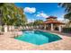 Resort-style pool with ample lounge chairs, a pool house, and barbecue grills for community members at 4912 Sabal Lake Cir, Sarasota, FL 34238