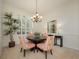 Dining room features a round table, elegant chandelier and plantation shutters at 4912 Sabal Lake Cir, Sarasota, FL 34238