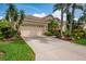 Inviting home featuring a barrel tile roof, neutral stucco, a front-entry two-car garage, and a concrete driveway at 4912 Sabal Lake Cir, Sarasota, FL 34238