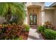 Elegant front entrance with double doors, decorative lighting, tile flooring, and meticulously maintained landscaping at 4912 Sabal Lake Cir, Sarasota, FL 34238