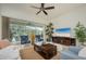 Comfortable living room with large windows, a ceiling fan, tile floors, and a view of the screened-in lanai at 4912 Sabal Lake Cir, Sarasota, FL 34238