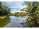 Picturesque pond with surrounding trees reflects the sky above at 4912 Sabal Lake Cir, Sarasota, FL 34238