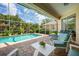 Screened in pool surrounded by tropical landscaping and comfortable patio furniture at 4912 Sabal Lake Cir, Sarasota, FL 34238