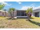 Landscaped backyard featuring a screened lanai, mature trees, and vibrant green grass at 5227 Aqua Breeze Dr, Bradenton, FL 34208