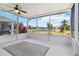 View of the lake from the screened lanai with ceiling fan and neutral-colored carpet at 5227 Aqua Breeze Dr, Bradenton, FL 34208