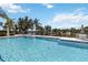 Community pool featuring lounge chairs, and views of pond and blue skies with puffy white clouds at 5227 Aqua Breeze Dr, Bradenton, FL 34208
