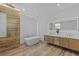 Modern bathroom featuring wood tile, gold fixtures, and freestanding tub at 532 Yale Rd, Venice, FL 34293