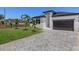 Exterior view with a paver driveway, small palm trees and green grass at 532 Yale Rd, Venice, FL 34293