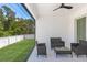Covered patio with dark wicker furniture overlooking fenced yard and mature trees at 532 Yale Rd, Venice, FL 34293