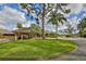 Picturesque clubhouse entrance with lush landscaping, covered drop-off, and an American flag at 5362 Huntingwood Ct # 16, Sarasota, FL 34235