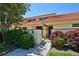 Charming one-story home with a red tile roof, a small courtyard, and mature landscaping at 5362 Huntingwood Ct # 16, Sarasota, FL 34235
