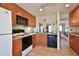 Well-lit kitchen featuring wood cabinets, modern appliances, and tile flooring at 5362 Huntingwood Ct # 16, Sarasota, FL 34235