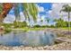 Scenic pond with a fountain, surrounded by palm trees and golf course views at 5362 Huntingwood Ct # 16, Sarasota, FL 34235