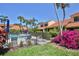 Community pool surrounded by lush landscaping with chairs, umbrellas and clear blue water, creating a relaxing oasis at 5362 Huntingwood Ct # 16, Sarasota, FL 34235