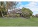 Backyard with screened lanai, lush trees and manicured bushes at 6001 Anise Dr, Sarasota, FL 34238