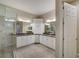 Bright bathroom featuring double sinks, white cabinetry and a glass-enclosed shower at 6001 Anise Dr, Sarasota, FL 34238