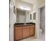 Bathroom featuring a vanity with granite countertop and framed mirror, as well as a toilet at 6001 Anise Dr, Sarasota, FL 34238