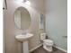 Powder room features pedestal sink, toilet and decorative mirror at 6001 Anise Dr, Sarasota, FL 34238