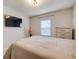 Comfortable bedroom featuring a mounted television, neutral walls, and natural light from a window at 6001 Anise Dr, Sarasota, FL 34238