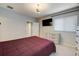 Comfortable bedroom features a mounted TV, three dressers, and a ceiling fan at 6001 Anise Dr, Sarasota, FL 34238