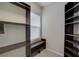 Walk-in closet with lots of custom dark wood shelving at 6001 Anise Dr, Sarasota, FL 34238