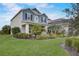 Beautifully landscaped front yard with a charming two-story home in the background at 6001 Anise Dr, Sarasota, FL 34238