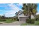 Side view of home featuring a two-car garage and well-kept lawn with landscaping at 6001 Anise Dr, Sarasota, FL 34238