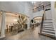 Spacious foyer with high ceilings, elegant staircase, and open access to dining and kitchen at 6001 Anise Dr, Sarasota, FL 34238