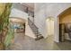 Elegant staircase with iron railing in a grand foyer, leading to the upper level at 6001 Anise Dr, Sarasota, FL 34238