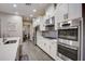 Modern kitchen with stainless steel appliances, white cabinetry, and granite countertops at 6001 Anise Dr, Sarasota, FL 34238
