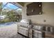 Outdoor kitchen with stainless steel grill and stone accents overlooking the pool at 6001 Anise Dr, Sarasota, FL 34238