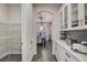 Walk-in pantry with wire shelving and butler's pantry featuring glass-front cabinets and a stylish backsplash at 6001 Anise Dr, Sarasota, FL 34238